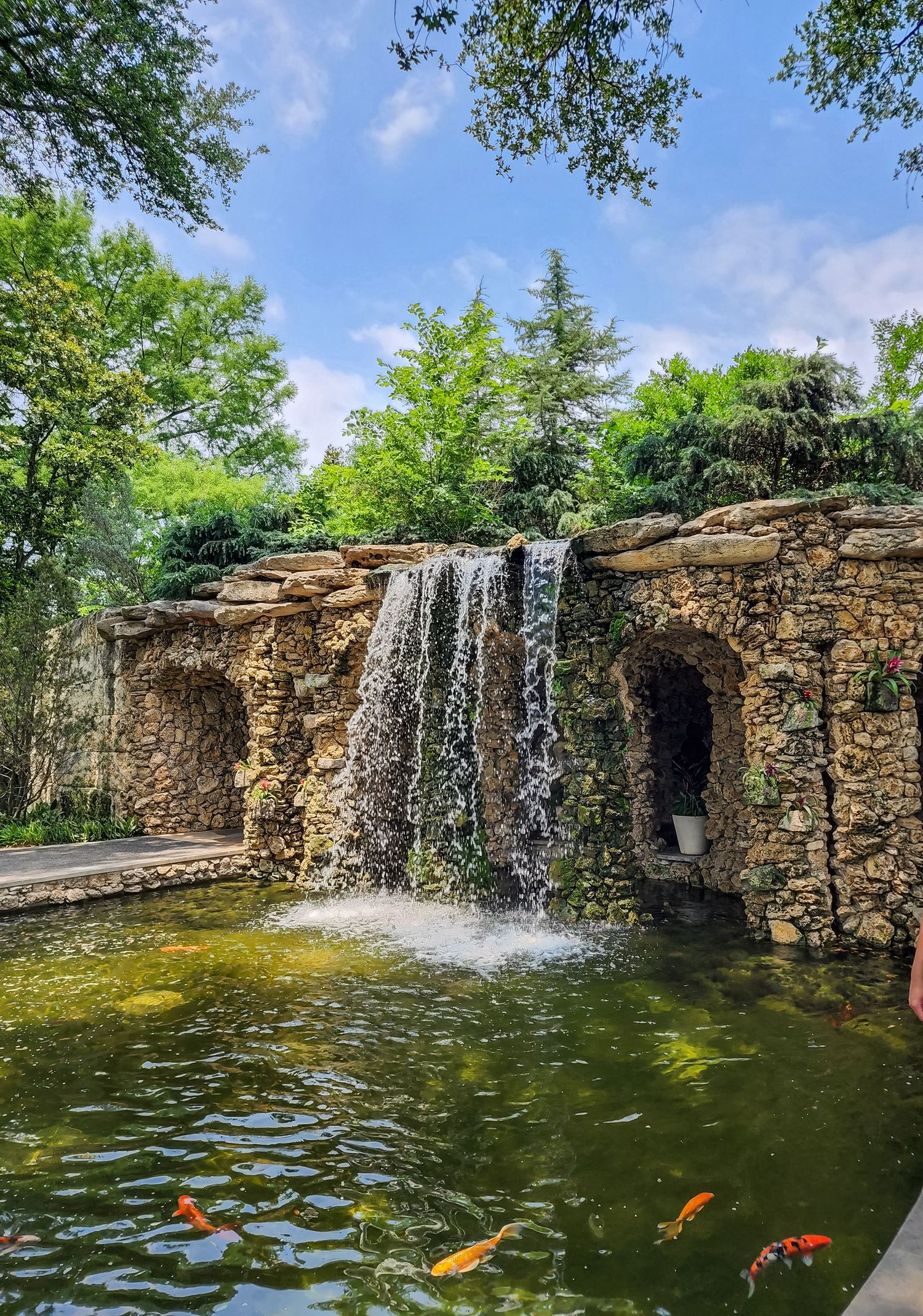 Rock waterfall flowing into a koi pond